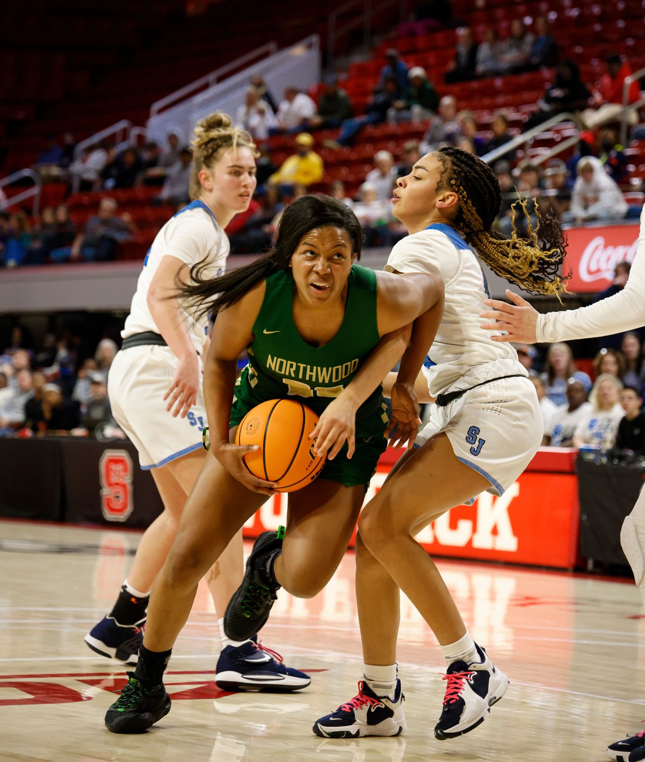 Northwood senior Olivia Porter (in green) splits two defenders on her way to the basket the Chargers' 72-40 win over the Enka Jets in the 3A women's basketball state championship game in Raleigh on Saturday. Porter (18 points, 5 rebounds) was named the Kay Yow Most Valuable Player after her performance in the victory.